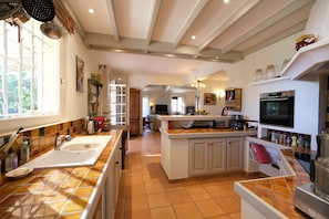 A spacious kitchen with a large island, a built-in oven, and a variety of kitchen appliances. - Air-co villa, Luberon views, heated pool, sleeps 8 (La Motte-d´Aigues)