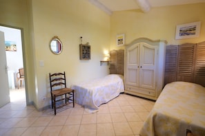 A bedroom with two beds, a wooden chair, a wardrobe, and a mirror on the wall. - Air-co villa, Luberon views, heated pool, sleeps 8 (La Motte-d´Aigues)
