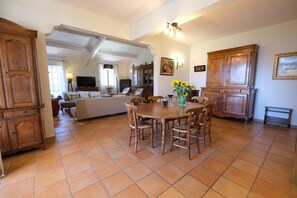 A spacious living area with a dining table, chairs, and a television. - Air-co villa, Luberon views, heated pool, sleeps 8 (La Motte-d´Aigues)