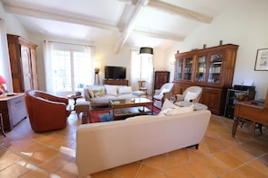 A spacious living room with a sofa, armchairs, a coffee table, and a television. - Air-co villa, Luberon views, heated pool, sleeps 8 (La Motte-d´Aigues)