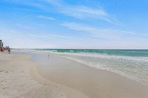 Ein Strand mit sandigem Ufer und Wellen.