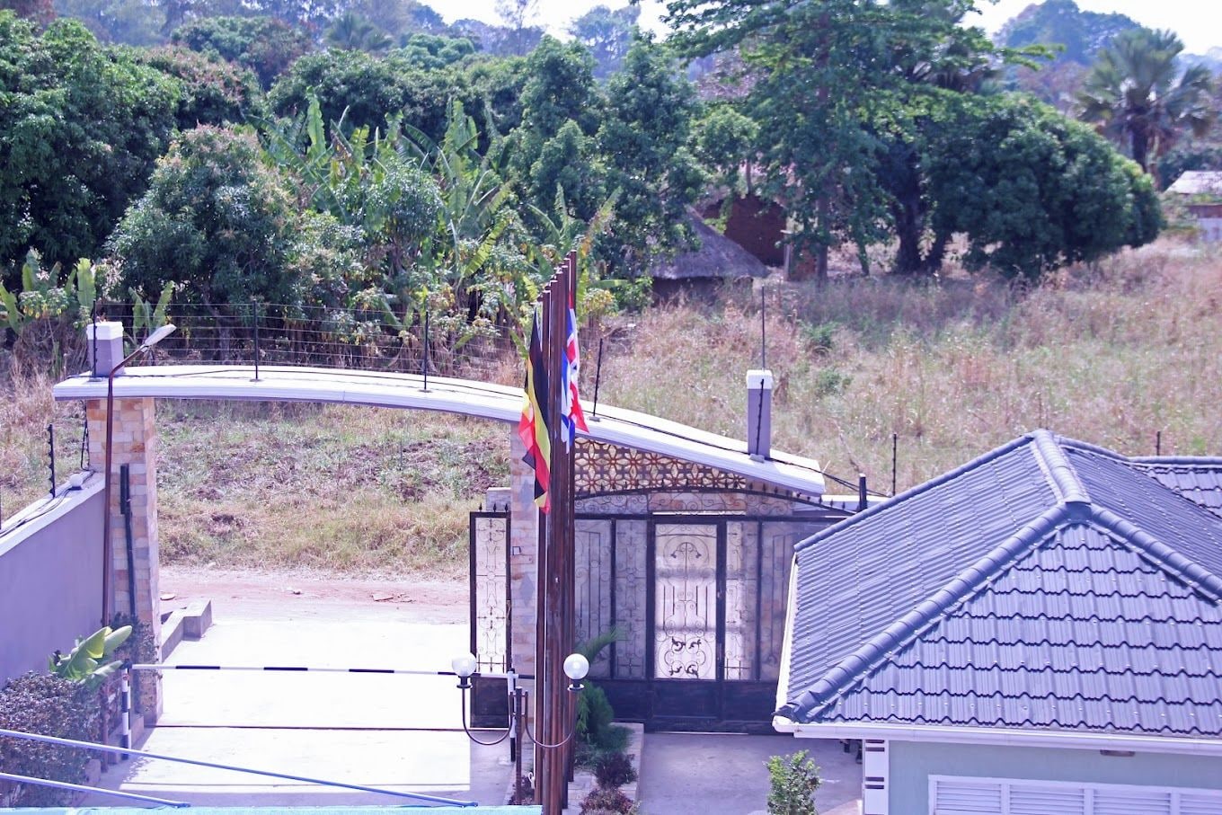 Zona residencial con una casa, un portón y un asta de banderola.