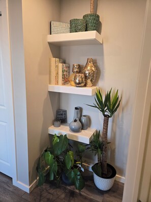 Un racó amb prestatges que contenen objectes decoratius i plantes.