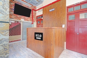 Un mostrador de recepción de hotel con un letrero que dice 'RECEPTION' y un letrero 'HOTEL', indicando que es un establecimiento de servicios empresariales.