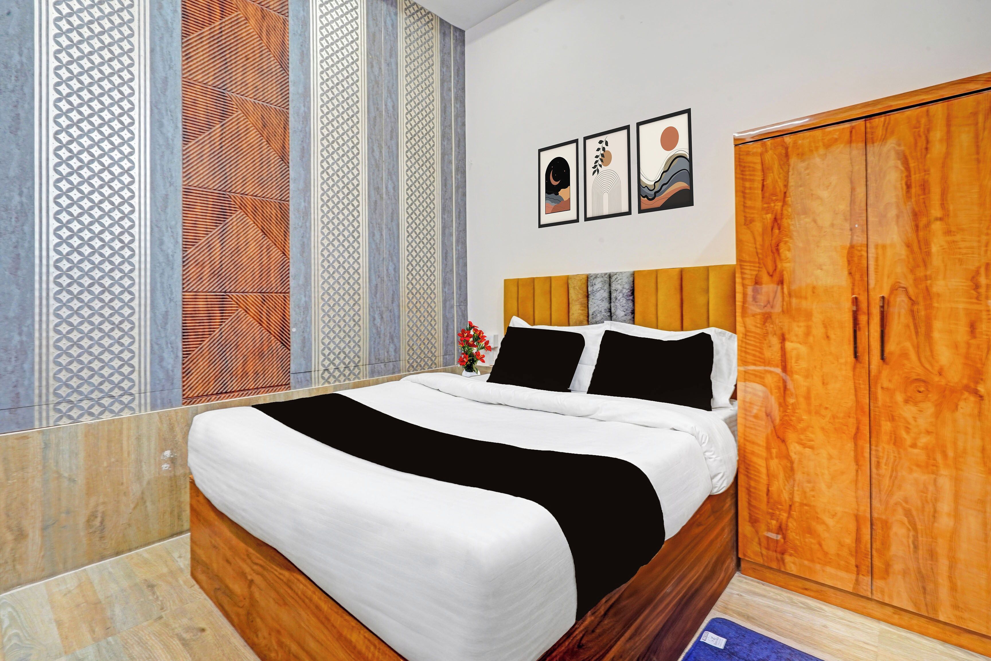 Un dormitorio con cama, armario y mesita de noche con un florero.