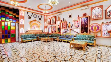 Una habitación con muebles ornamentados, piso estampado y decoración en las paredes.