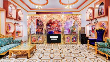 Una habitación ricamente decorada con sofás ornamentados, una exhibición central y un suelo estampado.