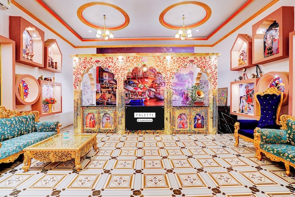 A lavishly decorated room with ornate sofas, a central display, and a patterned floor.