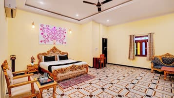 A hotel room with a large bed, a ceiling fan, a decorative wall piece, a patterned floor, and a window with curtains.