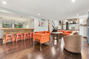 A modern interior with a bar area, seating, and a staircase. - Wooded golf Course Retreat (Westerville)