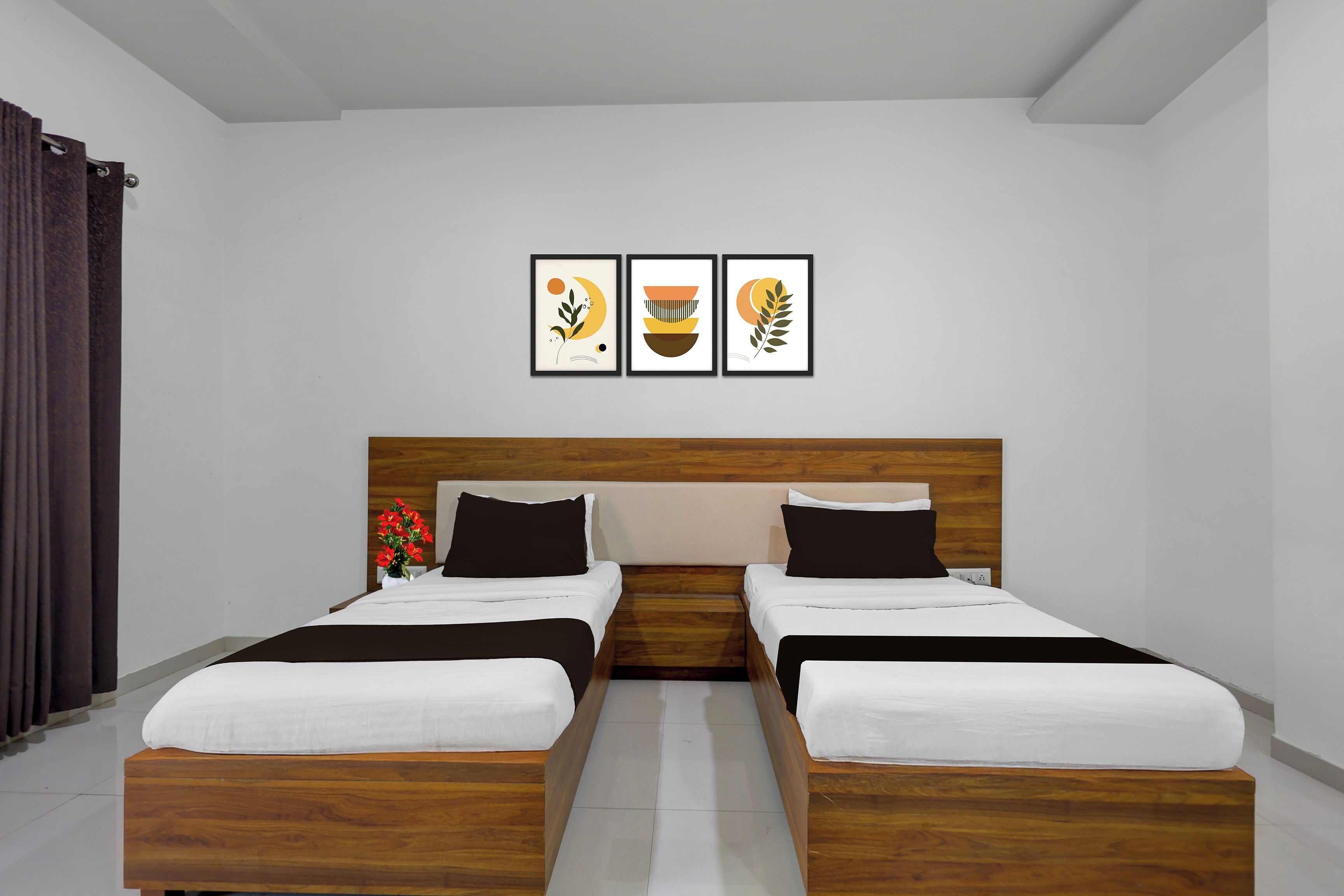 Une chambre avec un lit double doté d’une tête de lit en bois, deux tables de chevet et trois œuvres d’art encadrées accrochées au mur.