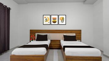 Une chambre avec un lit double doté d’une tête de lit en bois, deux tables de chevet et trois œuvres d’art encadrées accrochées au mur.
