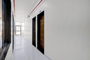 A corridor with white walls, a shiny floor, and doors with numbers 204 and 205.