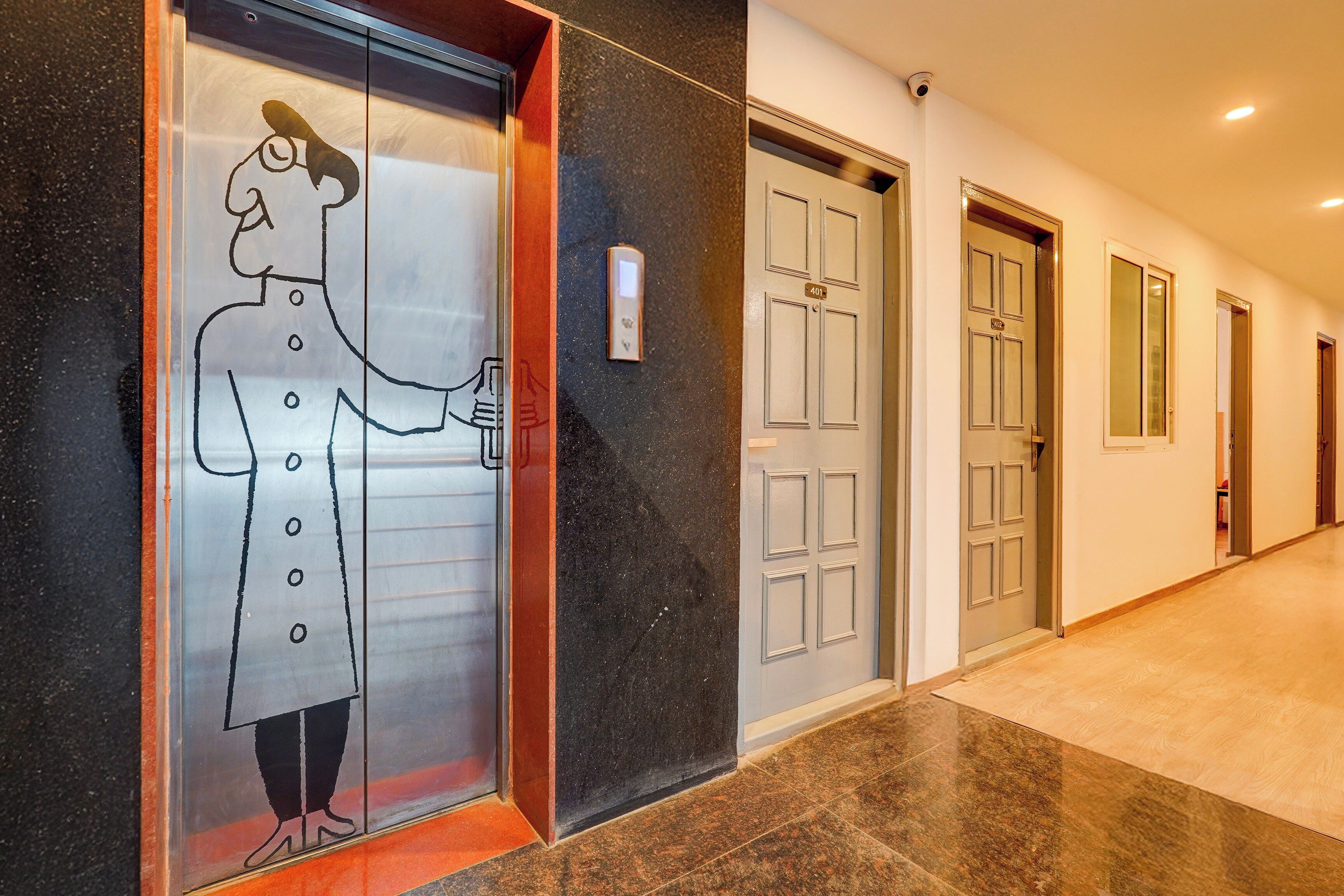 Pasillo de hotel con puerta de ascensor de vidrio que muestra un dibujo lineal sencillo de un hombre sosteniendo una bebida.