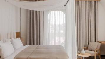 A bedroom with a bed, a bedside table, a chair, and a window with curtains.