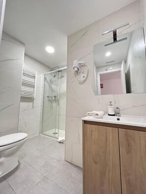 A modern bathroom with a glass shower enclosure, a wooden vanity, and a large mirror. - HOSPEDAJE LA PAZ (Madrid)