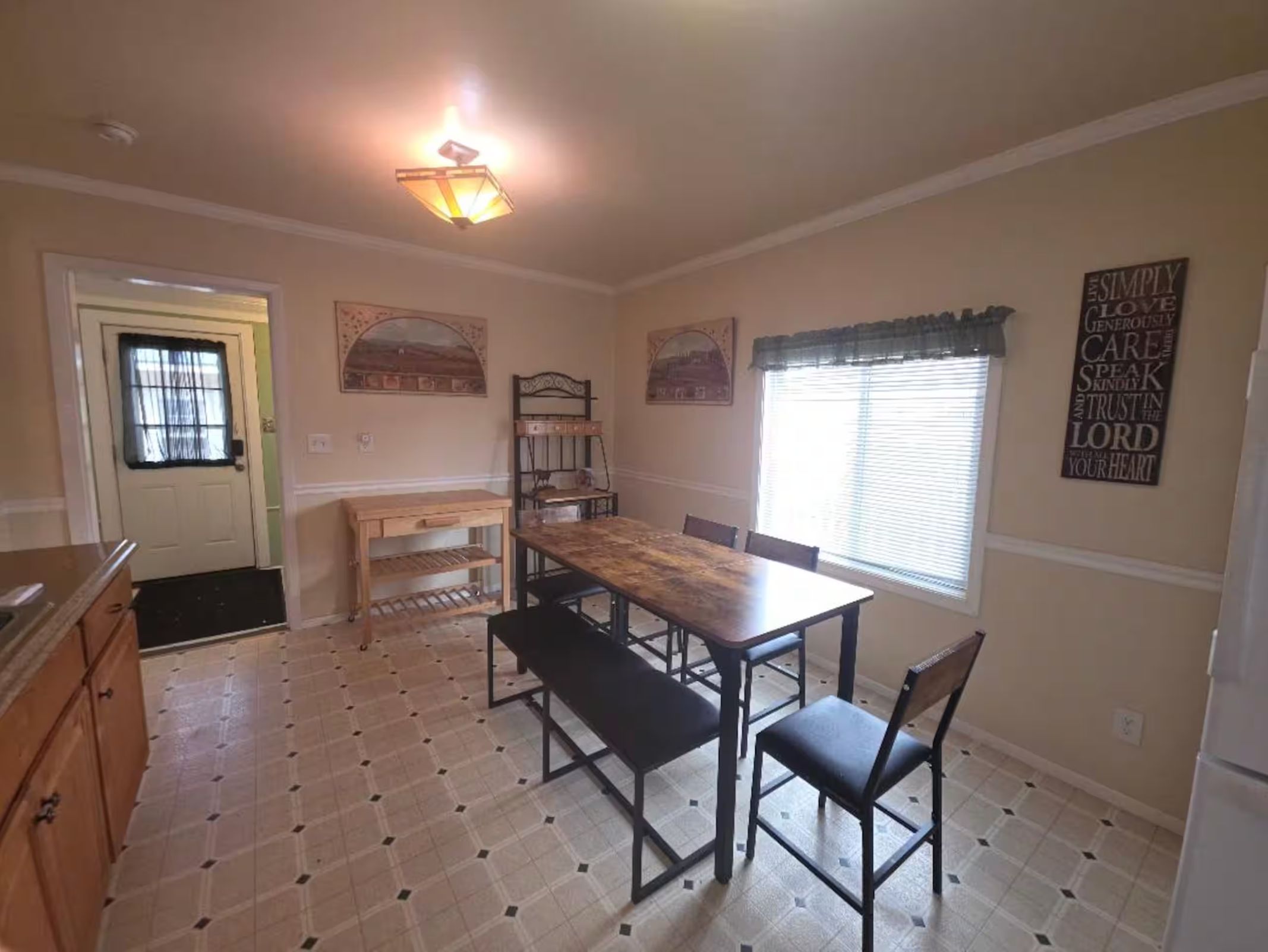 Dining space with a wooden table, bench seating, and patterned flooring.