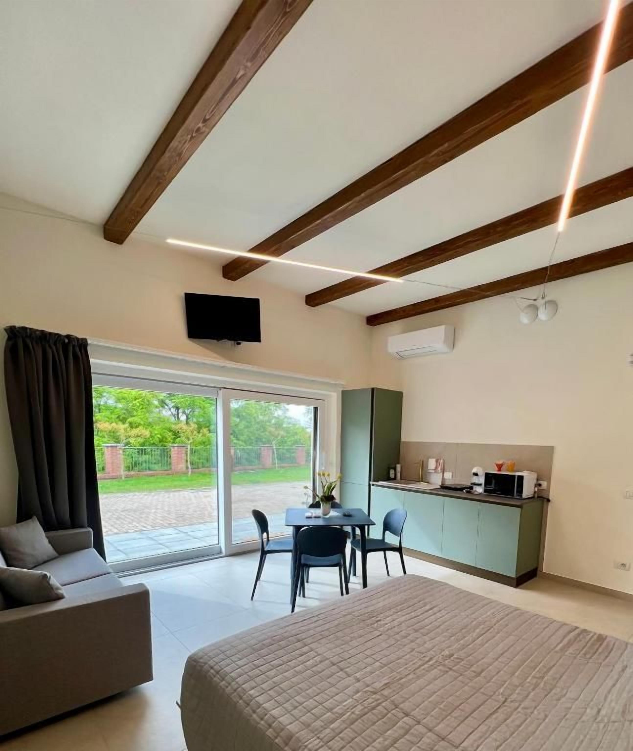 Un dormitorio con cama, sofá, mesa de comedor y zona de cocina.
