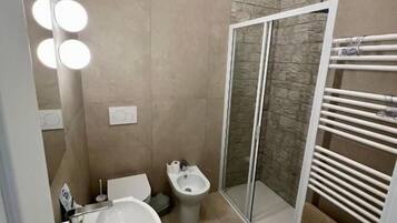 Un baño con ducha, inodoro y lavamanos.