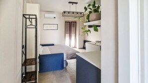 A compact bedroom with a bed, a bedside table, and a wardrobe.