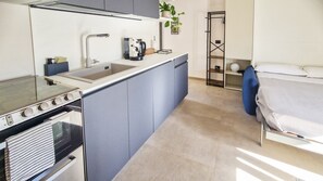 Una cucina compatta con fornello, lavello ed elettrodomestici moderni.