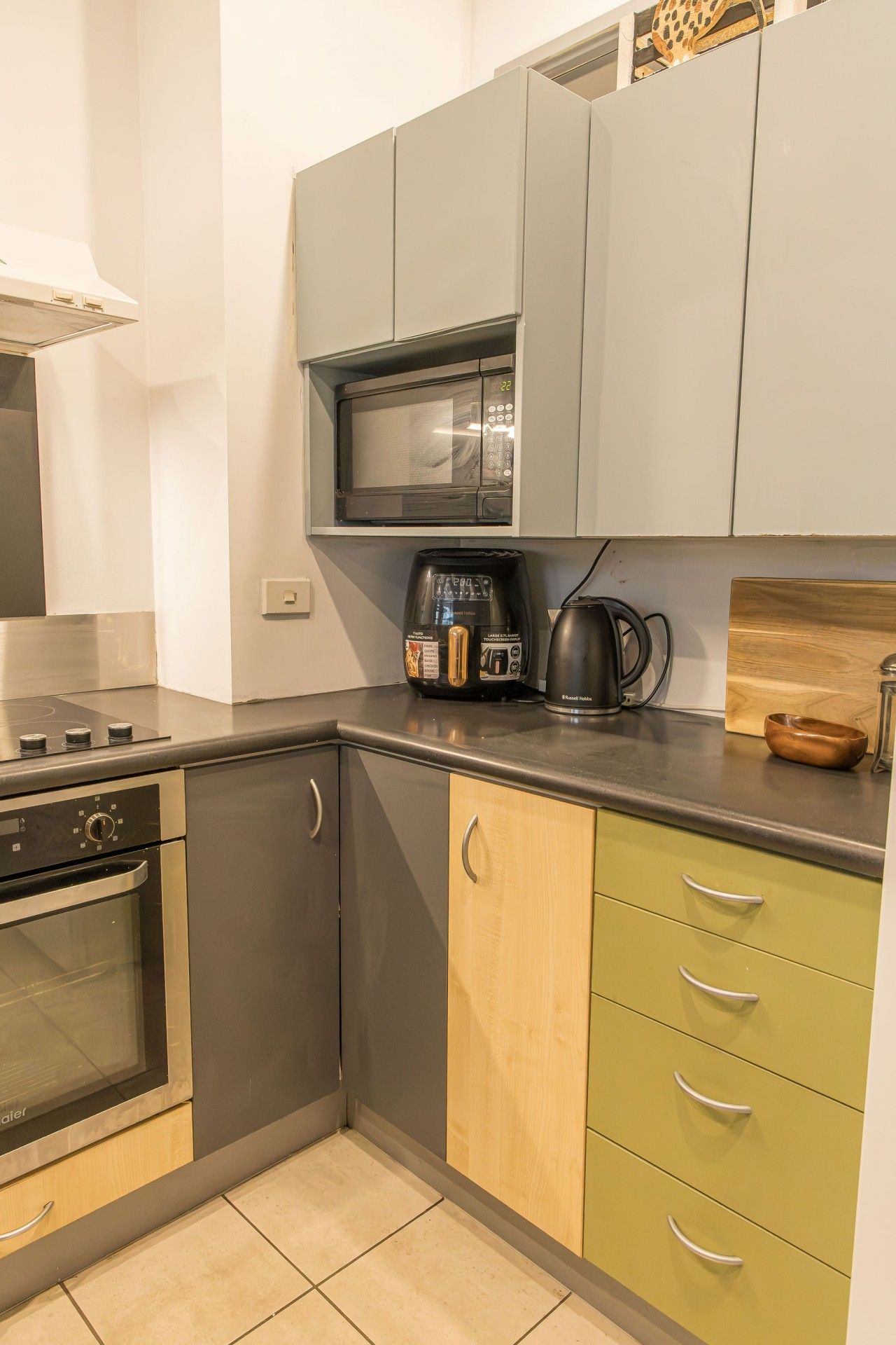 A kitchen with a microwave, coffee maker, and a stove.