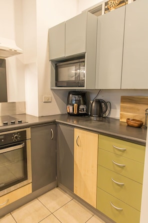 A kitchen with a microwave, coffee maker, and a stove. - Spacious 3-Bedroom Stay in Central Wellington (Wellington)