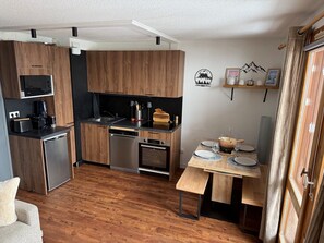 A compact kitchen with wooden cabinets, a microwave, a coffee maker, and a dishwasher. - New Listing (Les Avanchers-Valmorel)