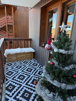 A wooden deck with a bench, a Christmas tree, and a patterned rug. - New Listing (Les Avanchers-Valmorel)