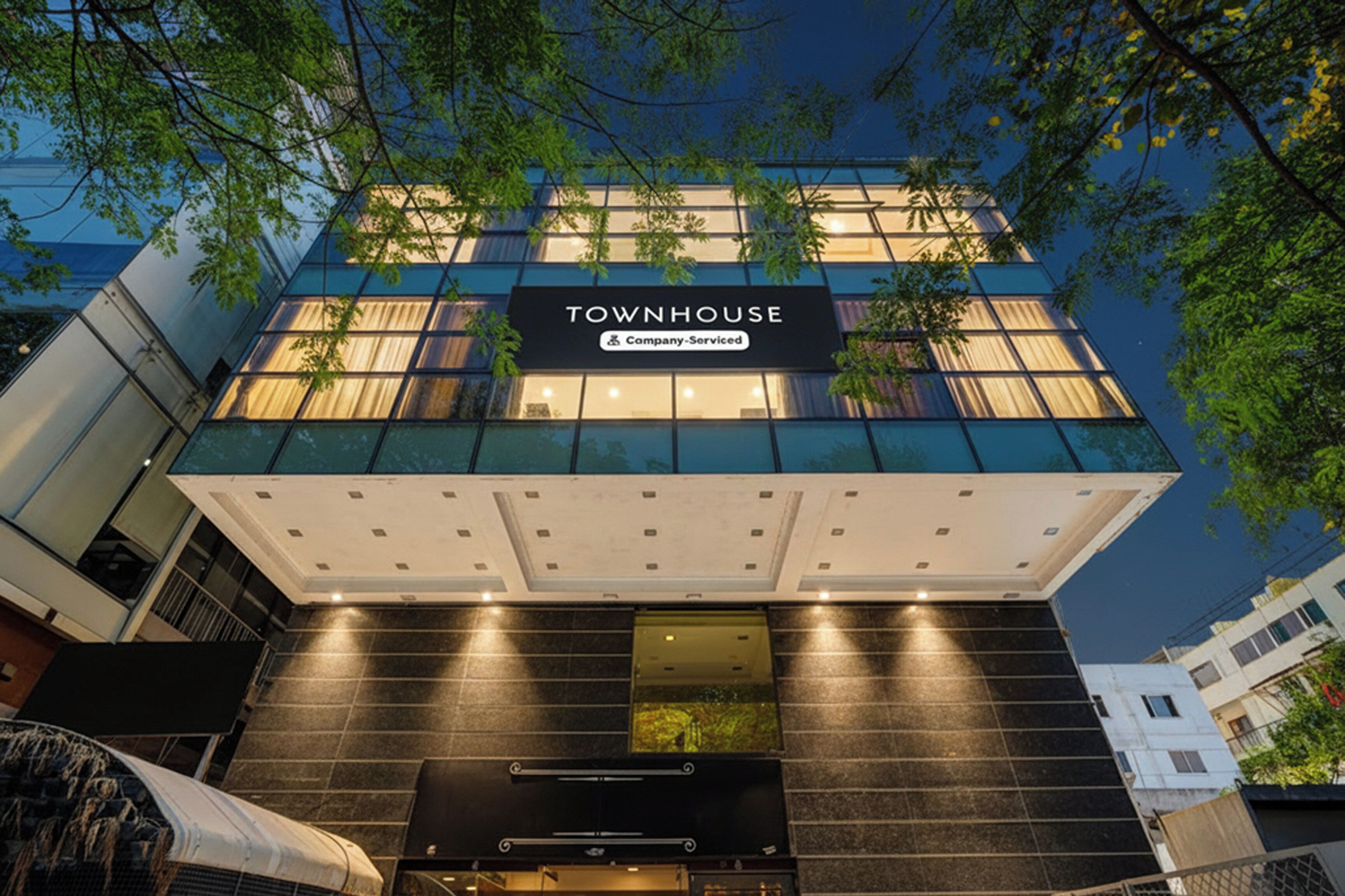 Un edificio moderno con un letrero que dice 'TOWNHOUSE' y 'Company-Serviced'.