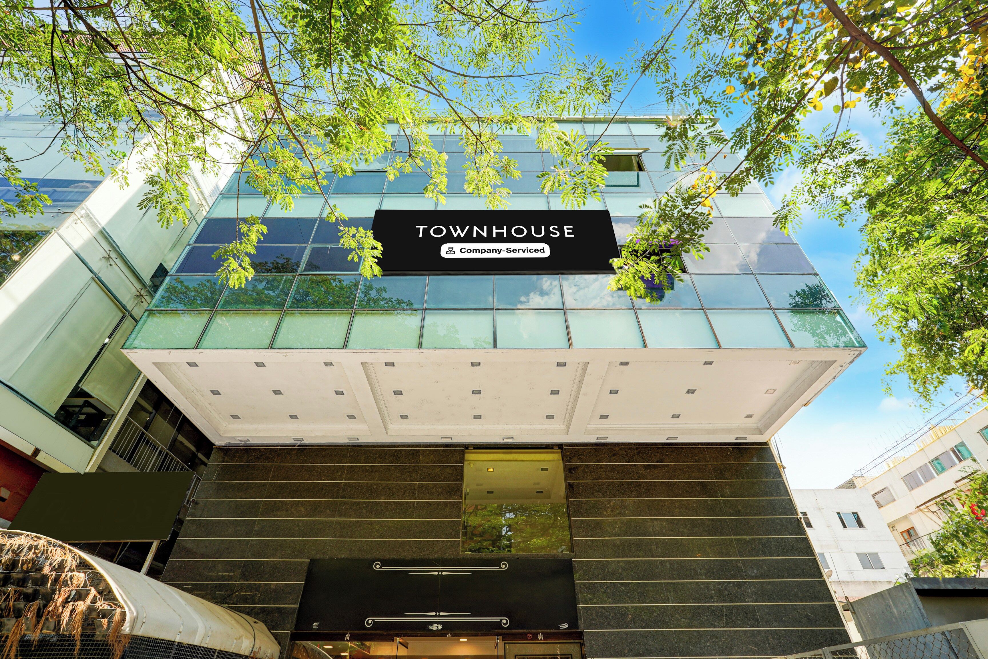 Un edificio moderno con un letrero que dice 'TOWNHOUSE' y 'Company-Serviced'.