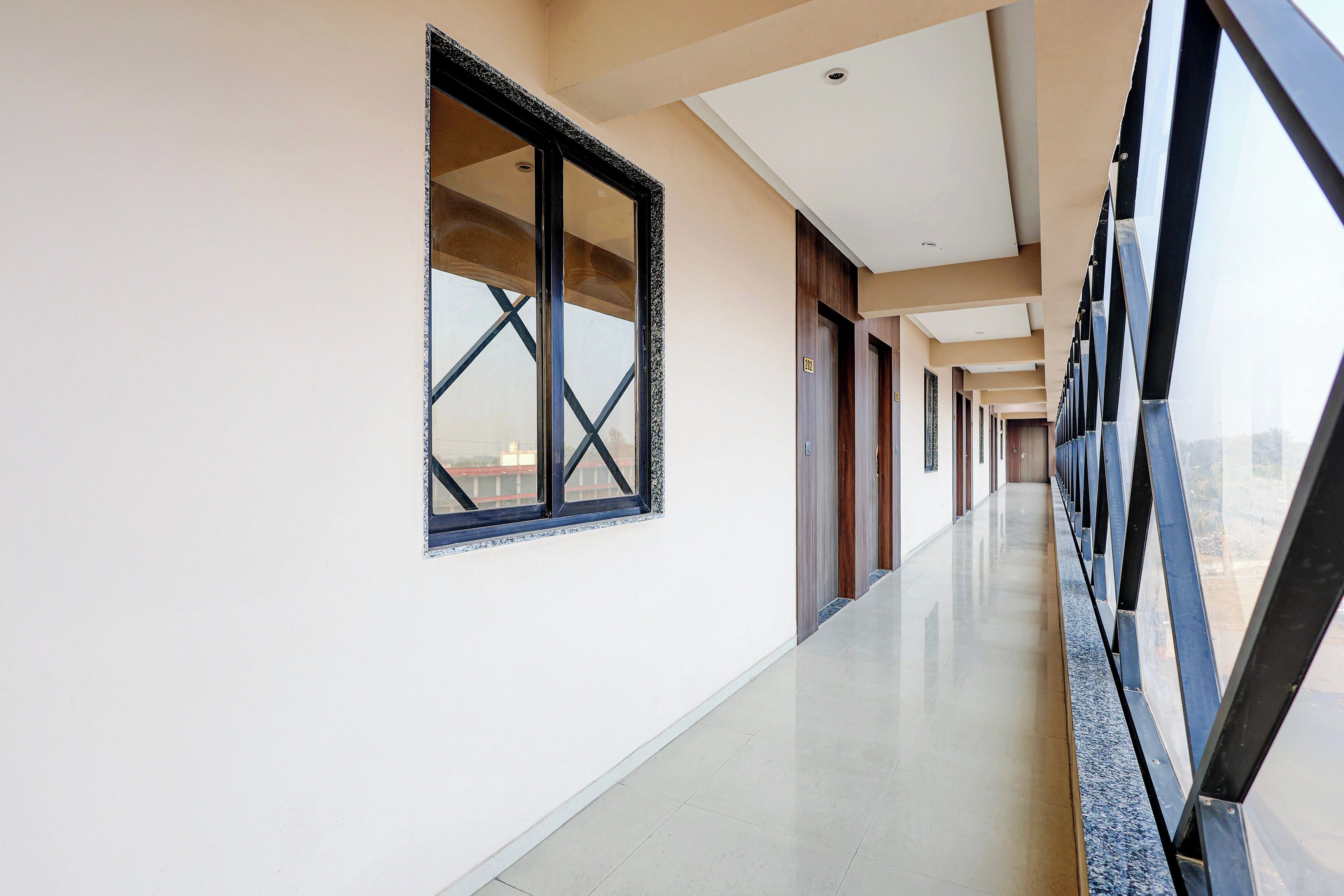 Un pasillo con una ventana, puertas e iluminación empotrada en el techo.