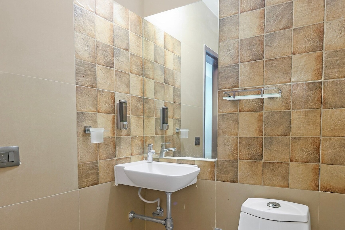 A bathroom with a white sink, a toilet, and a mirror.