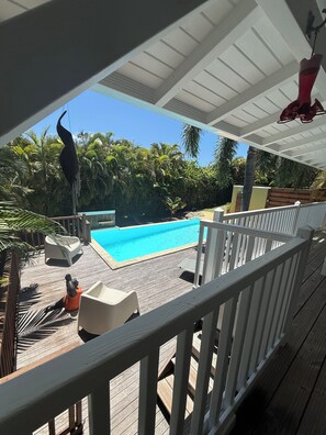 A wooden deck with a pool, surrounded by tropical vegetation. - New Listing (Saint-François)
