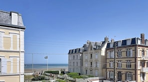 A coastal building with multiple stories, balconies, and a view of the sea. - New Listing (Cabourg)