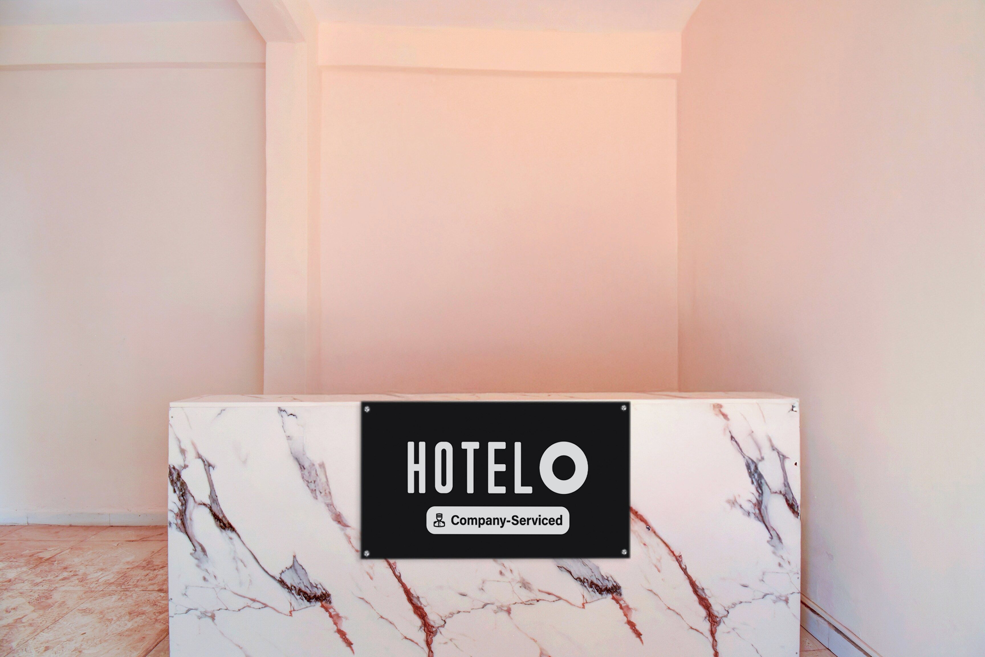 A hotel reception desk with a marble top and a sign that reads 'HOTEL O Company Serviced'.