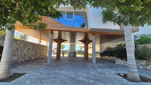 Un bâtiment moderne doté d’un mur en pierre, d’un espace d’entrée abrité et offrant une vue dégagée sur le ciel.