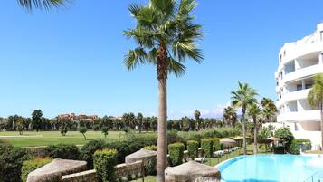 Ein Resort mit Schwimmbad, Palmen und Blick auf einen Golfplatz.