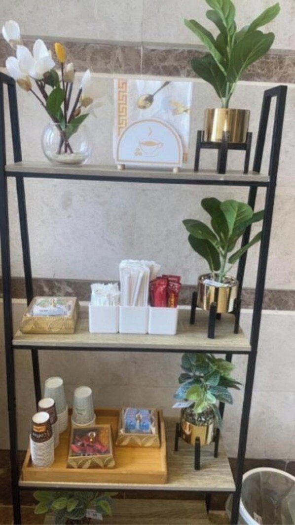 A metal shelf with various items including a plant, a framed picture, and some boxes.