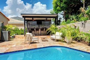 A swimming pool with a tiled edge, surrounded by outdoor furniture and plants. - The Cabana Club-3BR- Fantastic Outdoor Pool-Bar-TV (Fort Lauderdale)