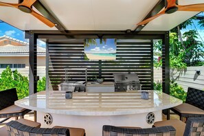 An outdoor bar area with a view of a beach, a grill, and seating. - The Cabana Club-3BR- Fantastic Outdoor Pool-Bar-TV (Fort Lauderdale)
