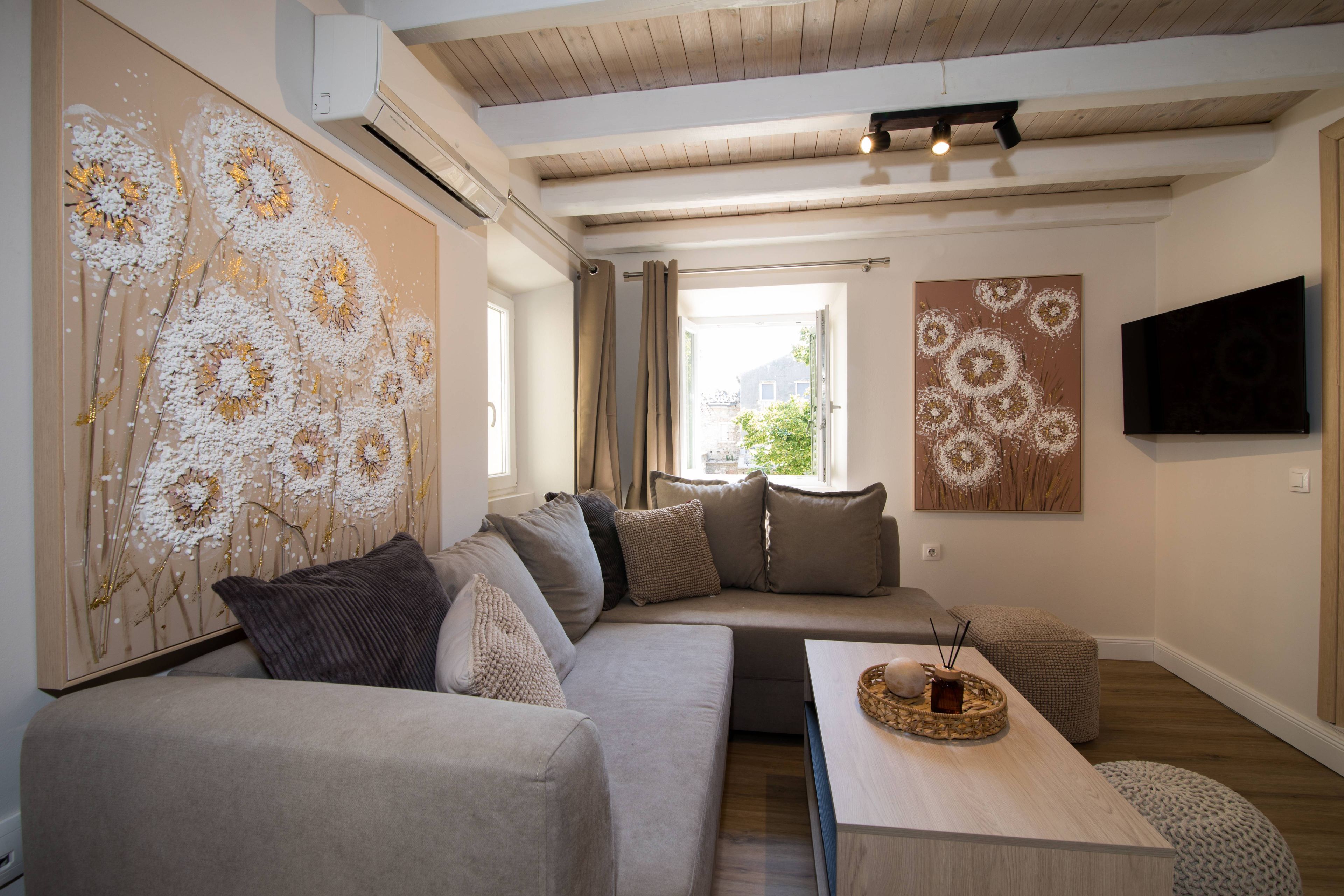 A modern living room with a sofa, a coffee table, and artwork on the walls.