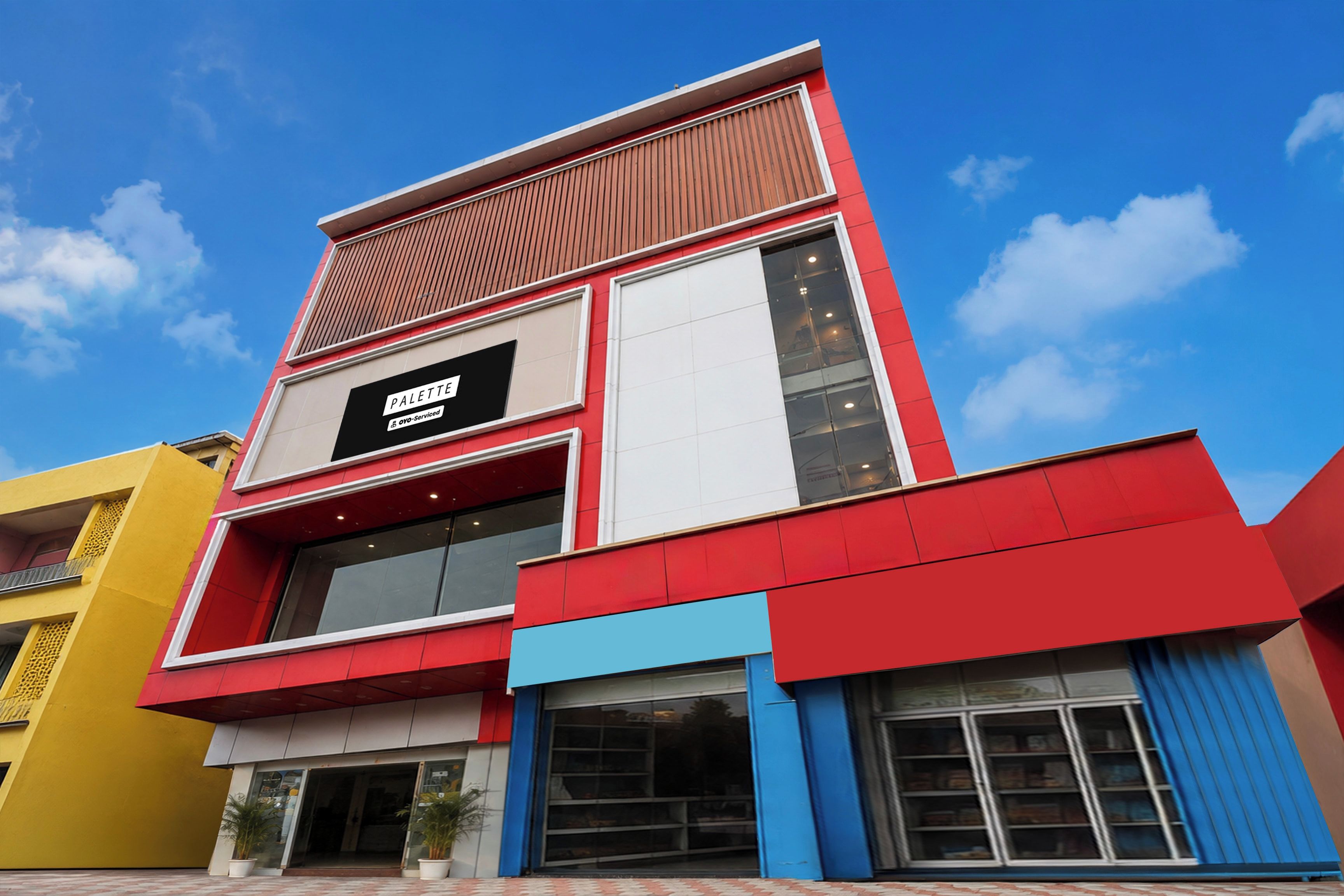 Un edificio moderno con un letrero destacado para 'PALETTE' y alojamientos 'OYO-Serviced'.