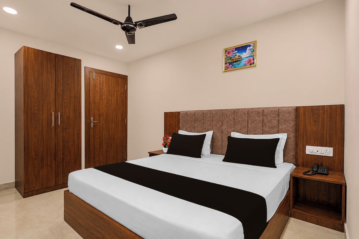 A bedroom with a bed, nightstands, a ceiling fan, a wardrobe, and a wall-mounted painting.