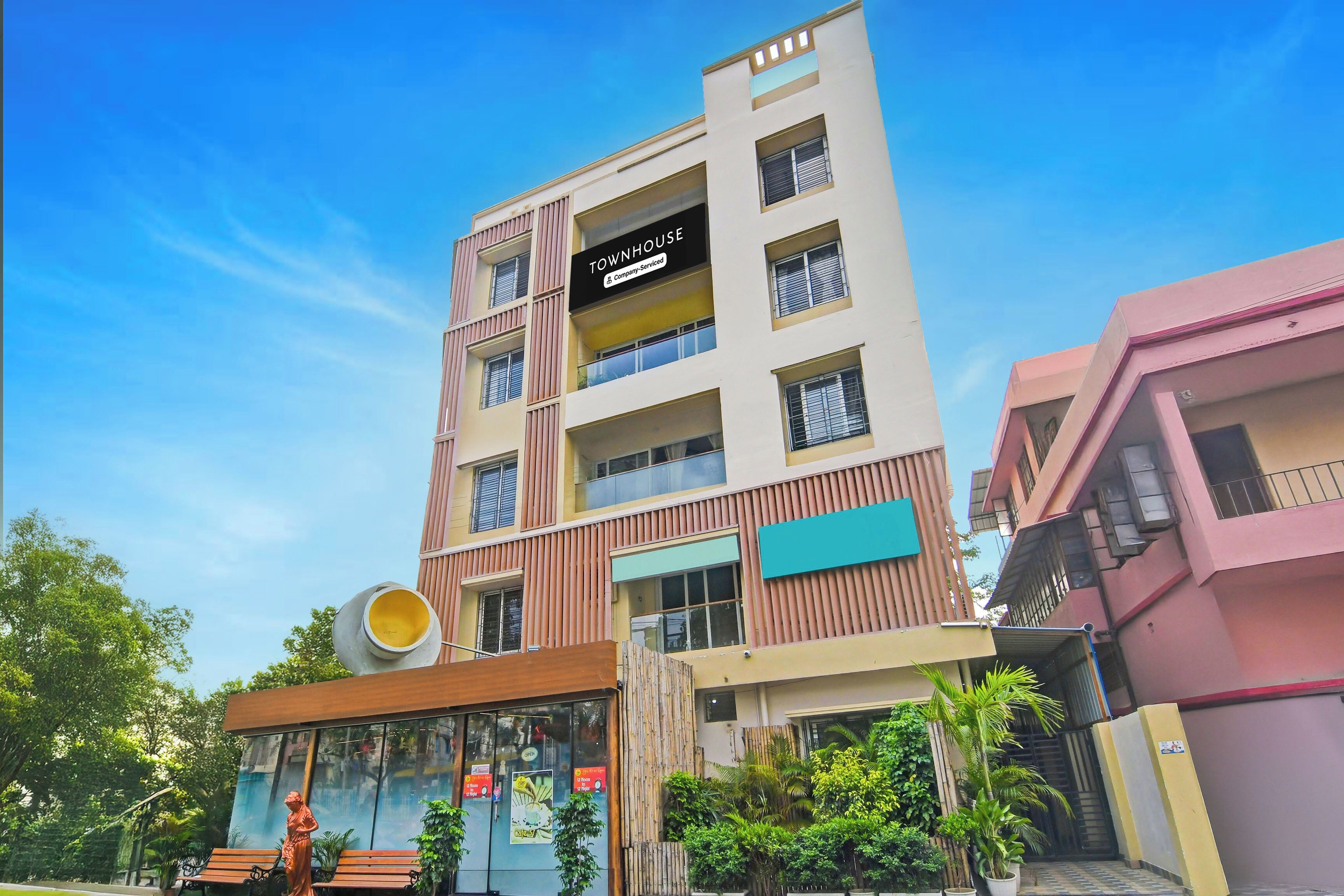 A multi-story building with a sign indicating it is a company-serviced townhouse.