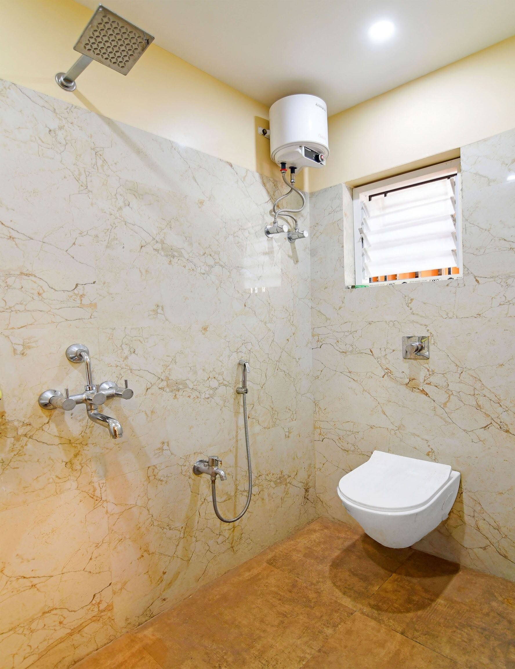 Un baño con ducha, inodoro y calentador de agua.