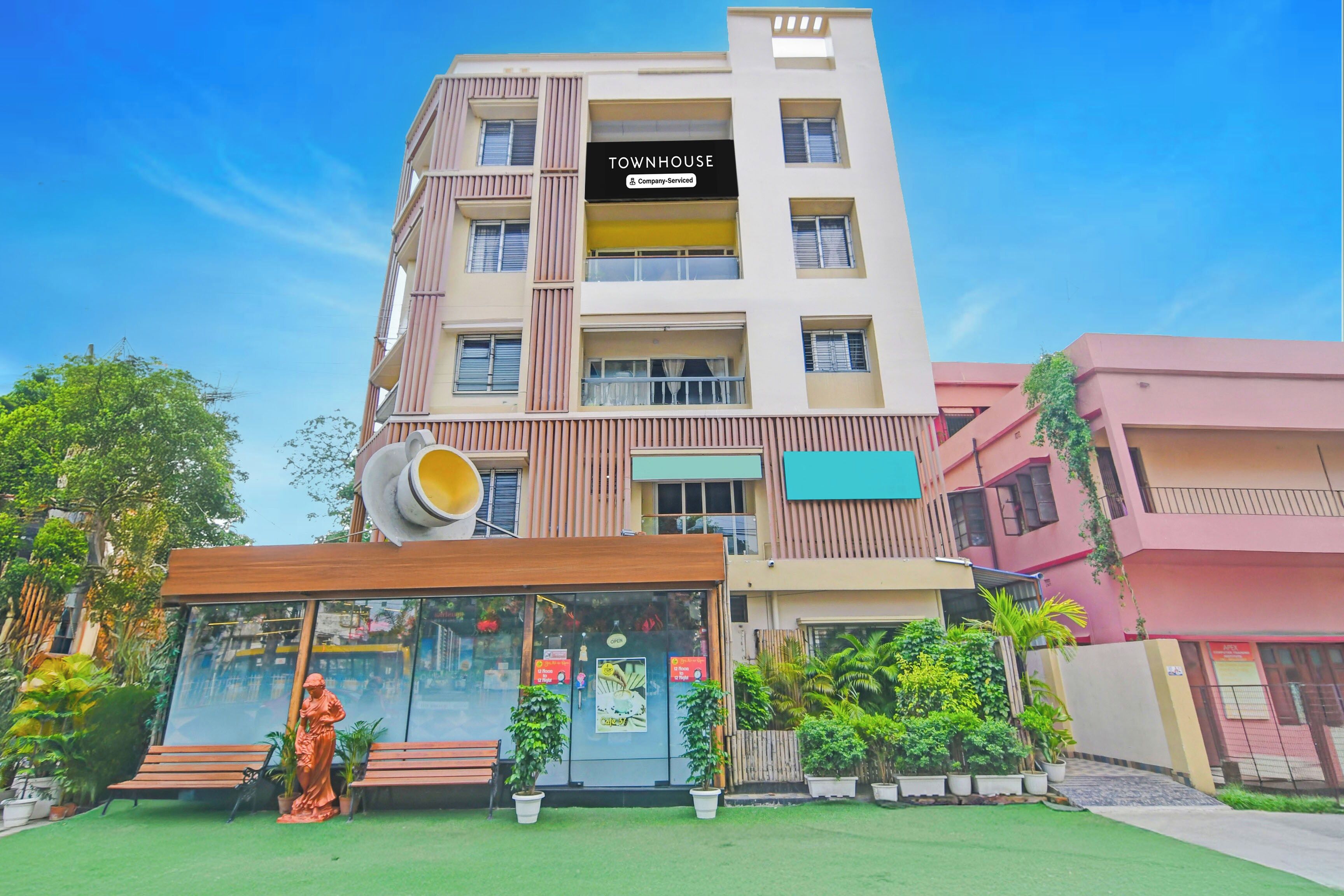 Un edificio de varios pisos con un letrero que dice 'TOWNHOUSE Company Service'.