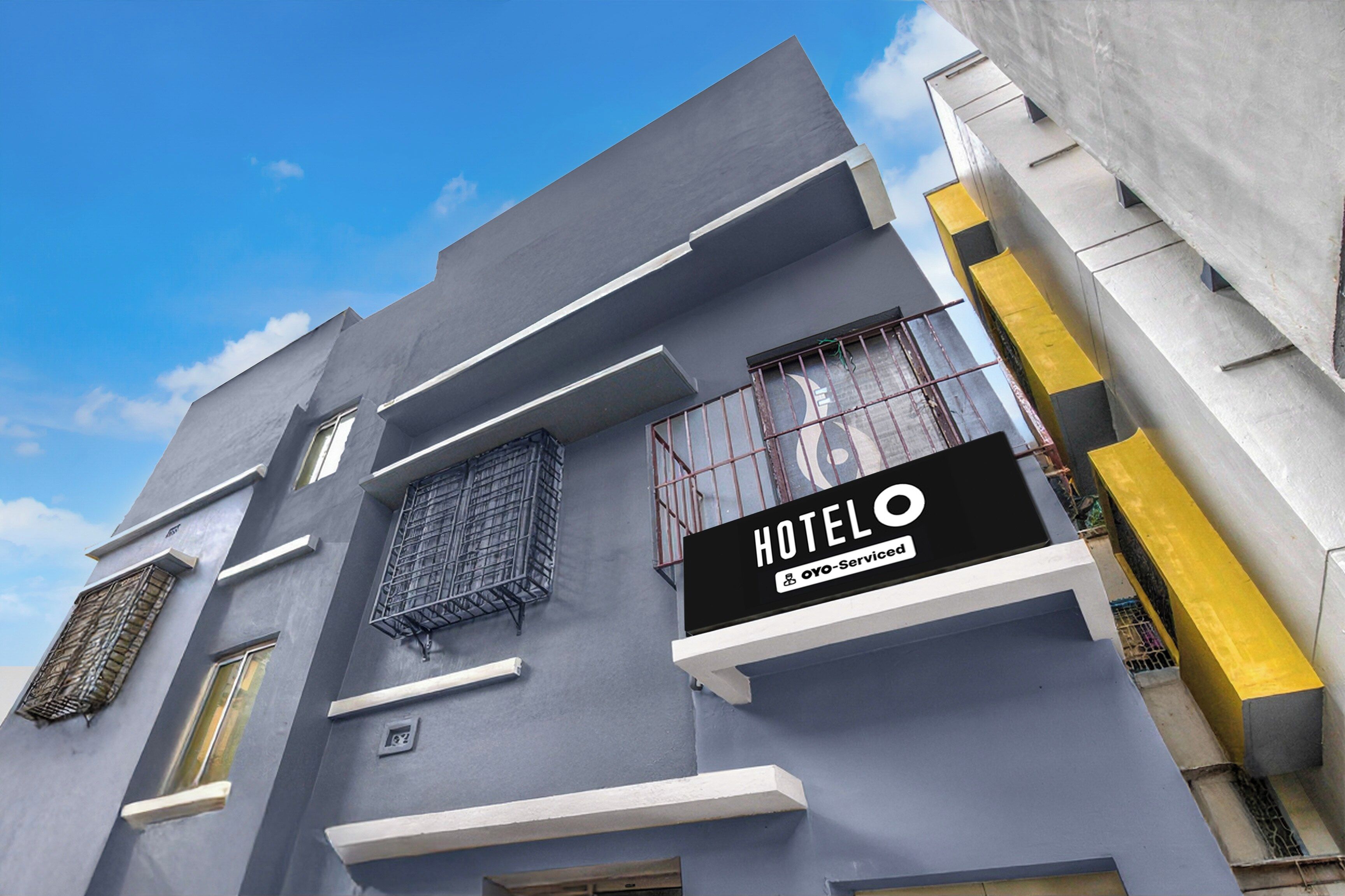 A hotel building with a sign indicating it is serviced by OYO.