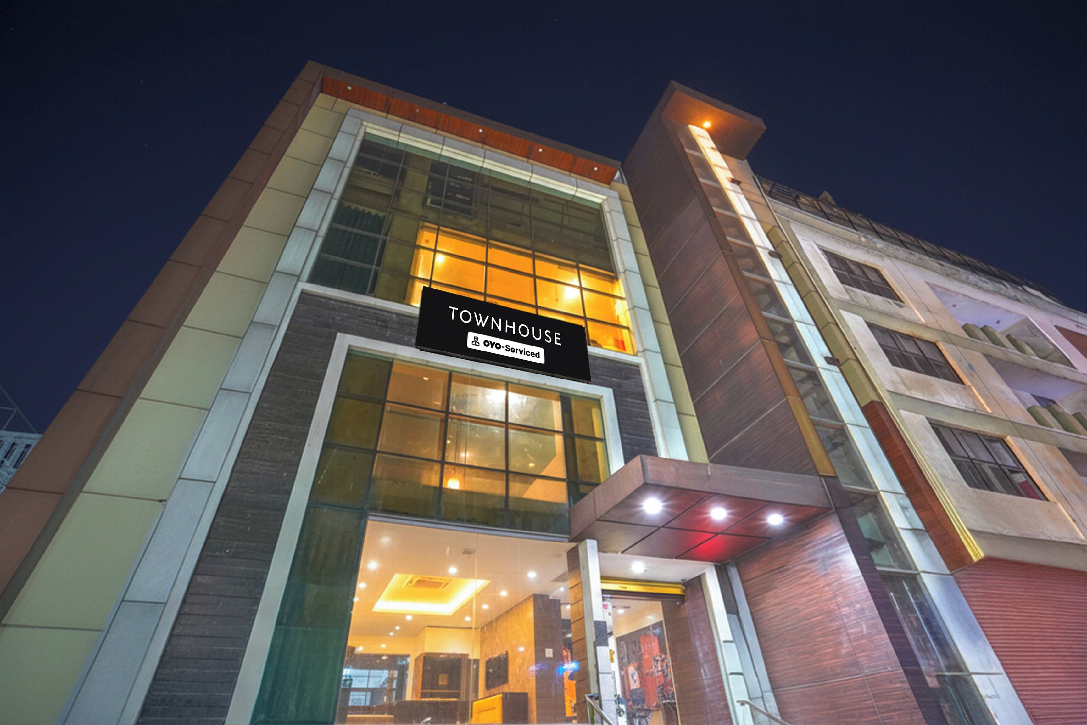 Un edifici modern amb un rètol que diu 'TOWNHOUSE' i 'YOY-Serviced'.