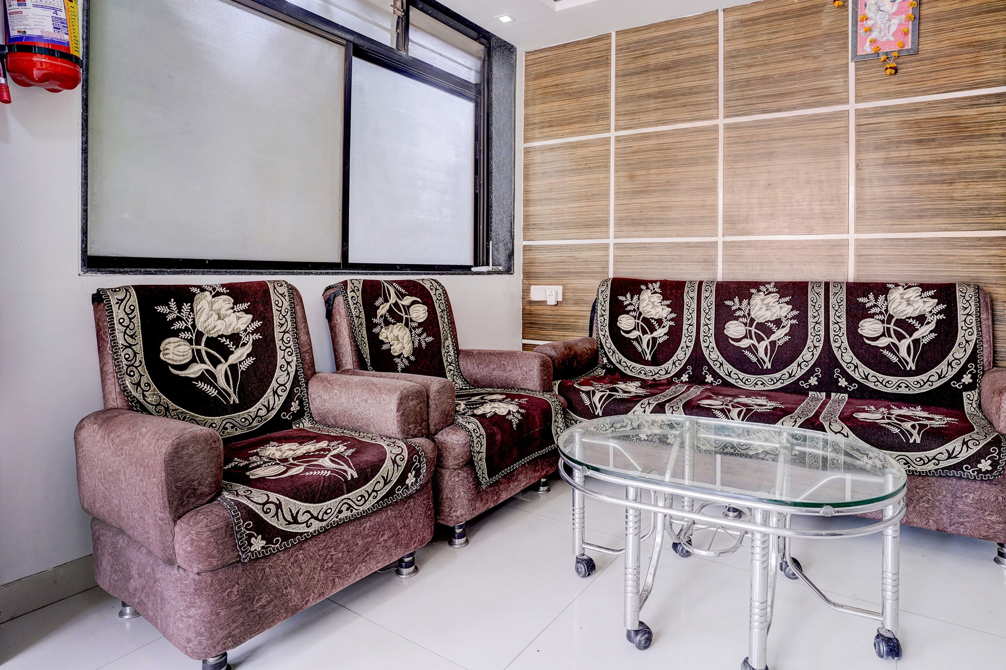 Una habitación con un conjunto de sofá, una mesa de centro de vidrio y una pared con diseño de paneles de madera.